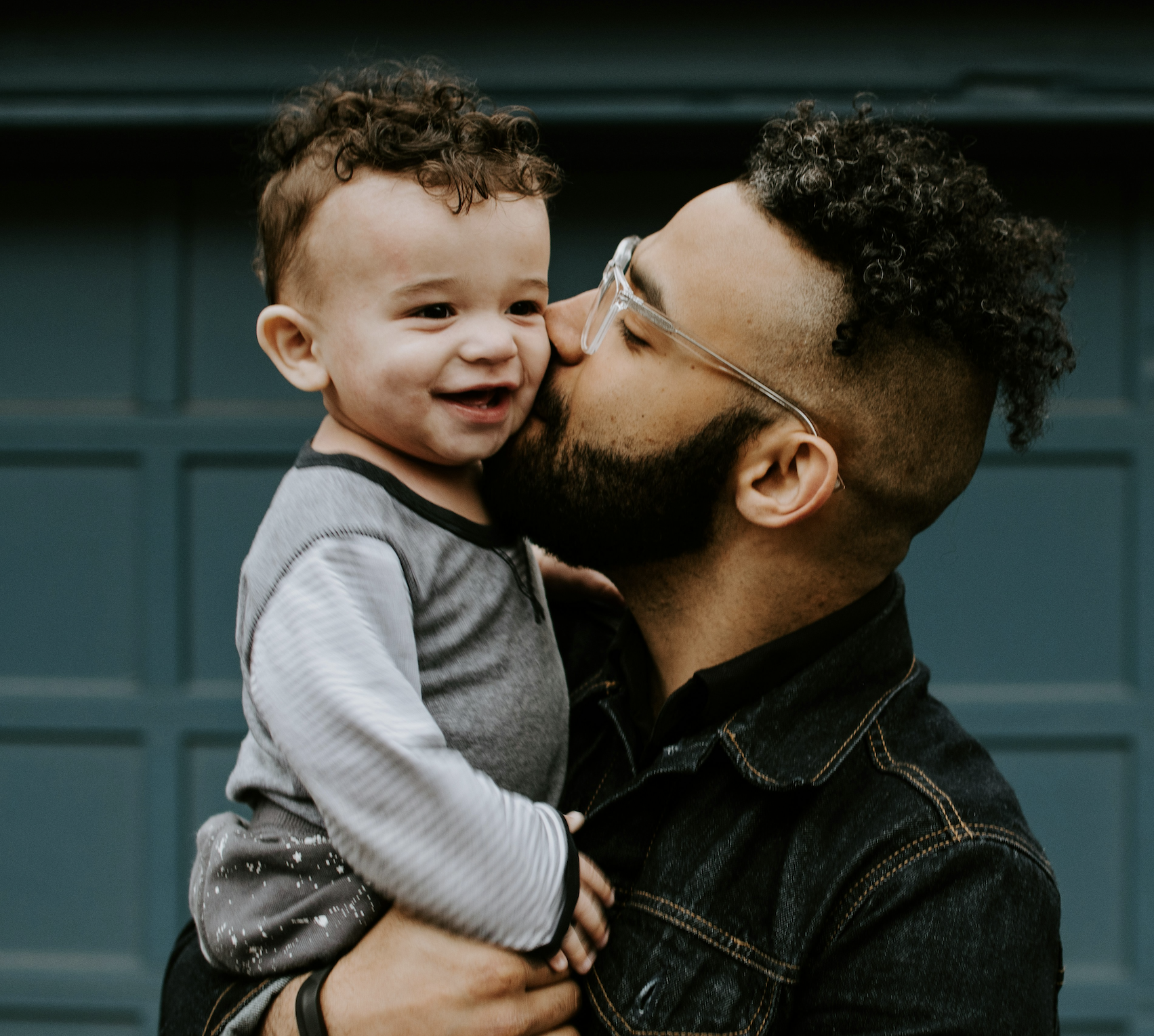 Father kissing smiling toddler
